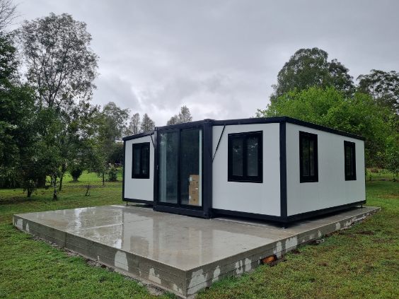 Expandable container home positioned and sealed on concrete pad