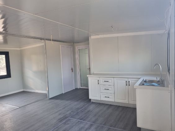 Expandable container home positioned and sealed on concrete pad